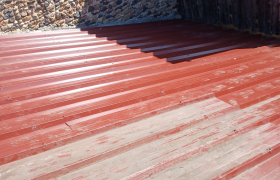 Dépose d’une ancienne toiture en tuiles et pose d’une couverture en bac acier rouge.